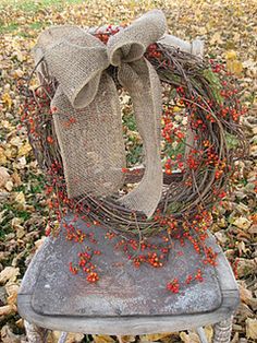 a chair with a wreath on top of it in front of some leaves and grass