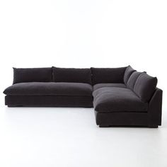 a large black couch sitting on top of a white floor