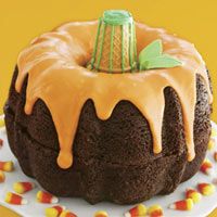 a bundt cake covered in frosting and candy corn on a yellow tablecloth