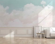 an empty room with a white couch and clouds painted on the wall behind it in pastel shades