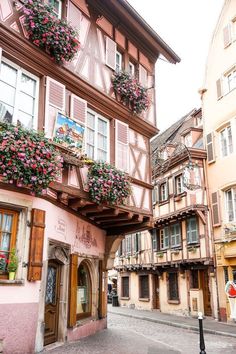 an old european street with flower boxes on the building's windows and balconies