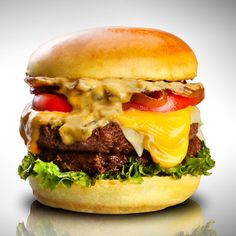 a hamburger with cheese, tomato and lettuce