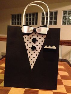 a black and white bag with a bow tie on it