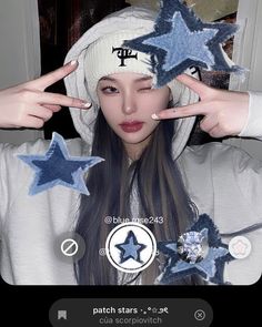 a girl with long hair wearing a white hoodie and blue stars on her head