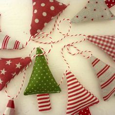 a group of christmas ornaments hanging from strings on a table with red and white polka dots