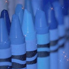 several blue and black crayons lined up in rows with sparkles on them