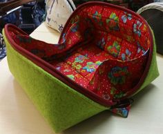 a green and red bag sitting on top of a table next to a white pillow