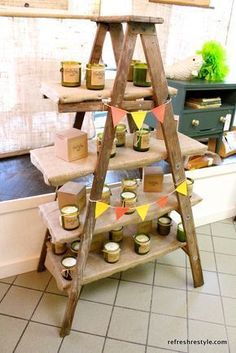 an old ladder is used as a shelf for candles and other things to decorate with