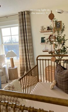 a baby's crib with a tree in it and some pillows on the bed