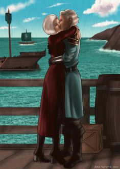 two people are hugging on a deck overlooking the ocean with ships in the water behind them