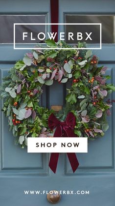 a blue door with a wreath on it and the words flowerbox shop now above it