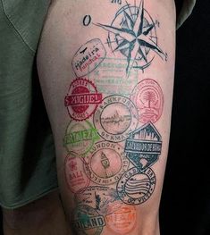 a person with a tattoo on their arm has many stamps all over his body and there is a compass in the middle