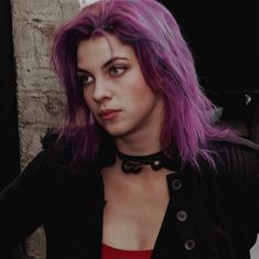 a woman with purple hair wearing a black jacket