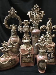 five vases with pearls and jewels on them are sitting in front of a black background