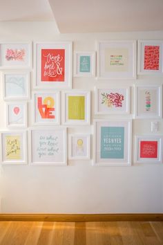 there are many framed pictures on the wall with words and phrases in them, including one that says love