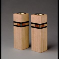 two wooden salt and pepper shakers with black bands on each side, one in the shape of a rectangle