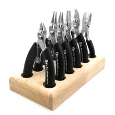 six pairs of black and silver scissors on a wooden holder