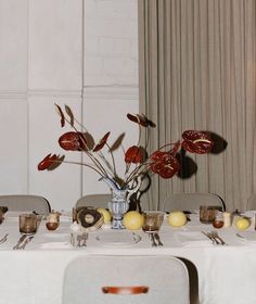 the table is set with silverware and flowers in a vase on top of it