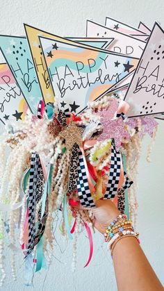 a person holding up a bunch of hair clips with the words happy birthday on them