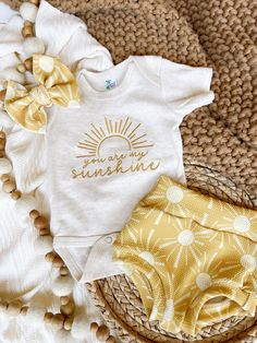 This is perfect for a cute summer outfit, coming home, birthday parties, and baby shower gifts, especially a cowgirl baby shower! The newborn pictures will be so cute! This sweet little oatmeal bodysuit is embroidered "You are my sunshine" in a beautiful golden yellow. The matching bummies in are floral with cute sun rays, stretchy, and so sweet! The hand-tied bow  is a perfect finish. The bummies are handmade in a matching stretchy, easy to wash fabric. Outfits fit true to size.  Newborn fits b Fitted Cream Onesie For Summer, Summer Cream Cotton Onesie, Cute Cream Onesie For Spring, Cute Cream Cotton Onesie, White Onesie For Summer Gift, White Onesie As Summer Gift, Fitted Onesie For Summer Gift, Summer Gift White Onesie, Family Matching Summer Birthday Onesie