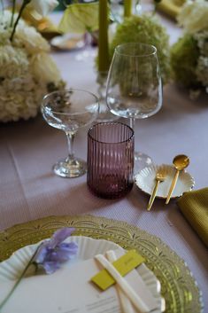 the table is set with wine glasses and place settings