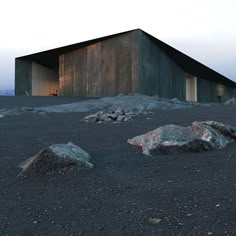 the building is made out of concrete and sits on top of some rocks