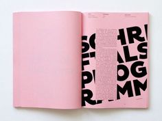 an open pink book with black letters on it