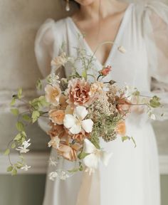 a woman holding a bouquet of flowers in her hands