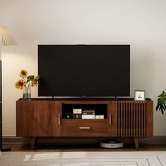 a flat screen tv sitting on top of a wooden entertainment center in a living room