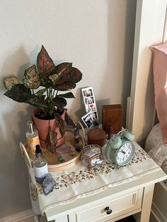 a white table topped with lots of different types of items next to a pink pillow