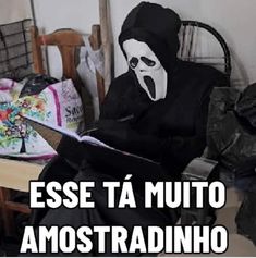 a person in a black mask sitting on a chair holding a knife with the caption esse ta muto amostradinho