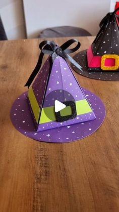 two paper hats sitting on top of a wooden table