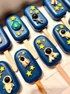 there are many pops that have space themed decorations on them, and one is made out of blue icing