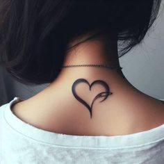 a woman's back neck with a heart tattoo on the upper part of her neck