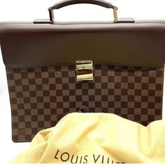 Up for sale is a stunning vintage Louis Vuitton Damier Ebene Altona PM Briefcase. This unisex piece is brand new and has the tags inside the interior Pocket. This classic piece comes in a rich brown color with a gold buckle closure. The briefcase is made of high-quality leather and features the iconic Louis Vuitton brand, making it a must-have for any fashion enthusiast. This briefcase model is part of the Louis Vuitton Damier product line and has a retail price of $3200. It's perfect for both m Important Documents, Fashion Enthusiast, Louis Vuitton Damier Ebene, Vintage Louis Vuitton, Damier Ebene, High Quality Leather, Luxury Brand, Louis Vuitton Damier, Timeless Pieces