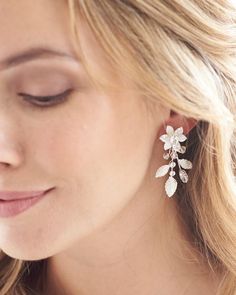 a close up of a person wearing some kind of earring with flowers on it