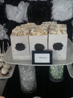 popcorn bags and marshmallows are sitting on a table with other desserts