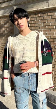 a young man standing in front of a brick building