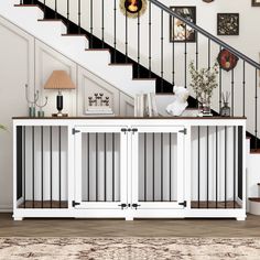 a white cabinet under the stairs with glass doors on each side and an area rug underneath it