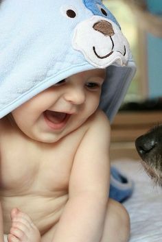 a baby with a towel on his head next to a dog