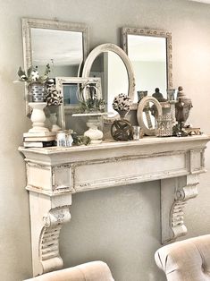 a white mantle with mirrors and vases on it