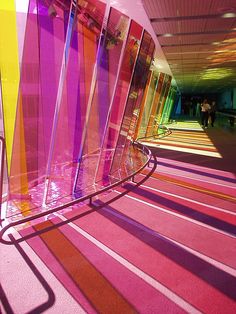 an abstract photo of colorful lines and colors in a hallway with pink, yellow, green, purple, orange, and red carpet