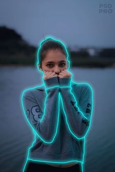 a woman standing in front of a body of water with her hands on her face