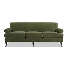 a green couch sitting on top of a white floor