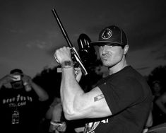 a man holding a baseball bat in his right hand and wearing a hat on top of his head