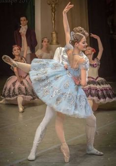 two ballerinas dressed in blue and white are dancing