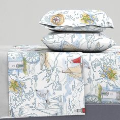 three pillows stacked on top of each other with boats and ships printed on the covers