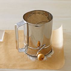 a metal mug sitting on top of a wooden table