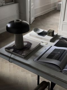 an open book sitting on top of a table next to a lamp and other items