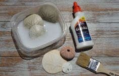 an assortment of seashells and glue on a wooden table with paintbrushes